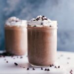 Chocolate protein shake topped with whipped cream, a delightful treat ready to be enjoyed.
