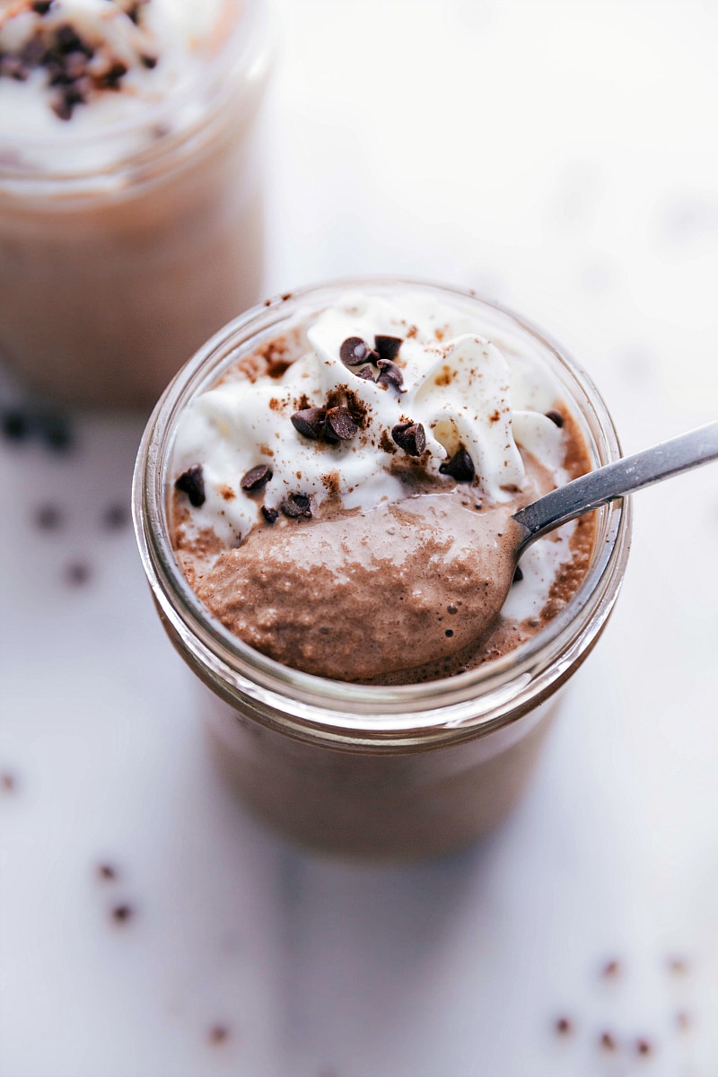 Spoonful of chocolate protein shake being lifted from the cup, a delicious moment about to happen.