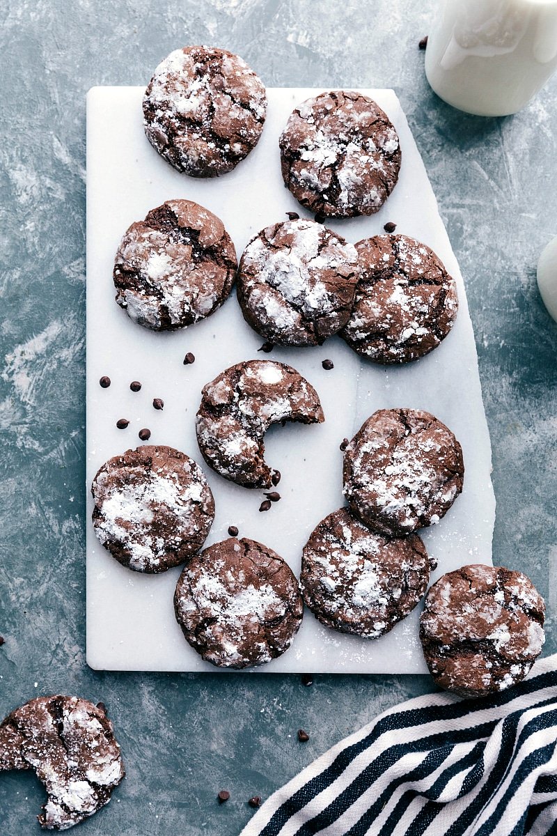 Fresh out of the oven, chocolate crinkle cookies dusted with powdered sugar, exuding a warm and inviting aroma.