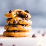 Stacked small batch pumpkin cookies with the top one featuring a missing bite, showcasing their texture.