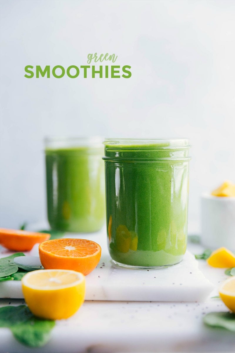 Vibrant green smoothie glasses on a table, encircled by fresh citrus slices.