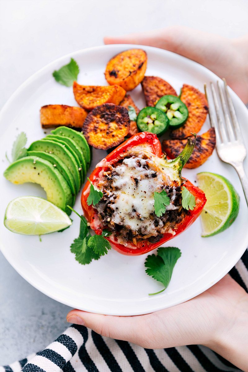 Person holding up plate filled with sweet pepper, avocado, and sweet potato