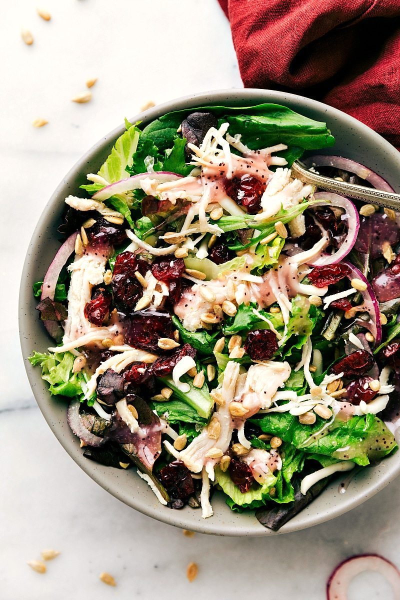A good-for-you mixed greens salad topped with leftover turkey (or chicken), red onions, dried cranberries, and sunflower seeds Recipe via chelseasmessyapron.com