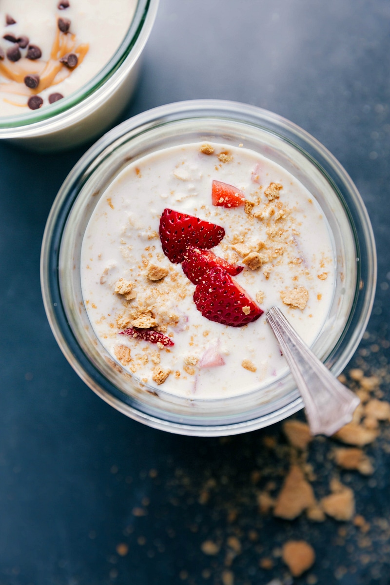 Finished strawberry cheesecake overnight oats, topped with fresh strawberries, ready for a delicious breakfast.