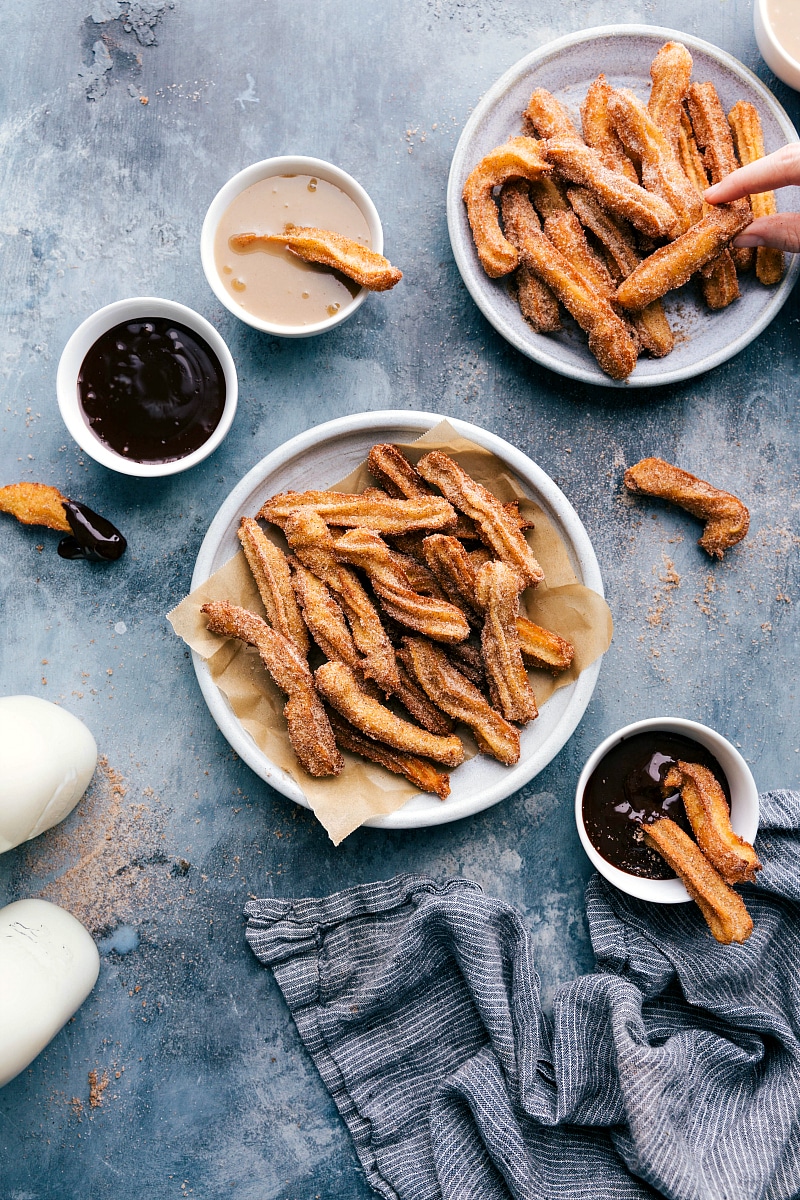 Overhead image of a plate of Churros and dipping sauces on the side