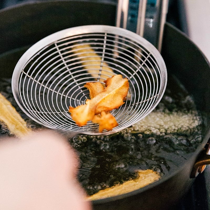 Dough frying to golden perfection in hot oil.