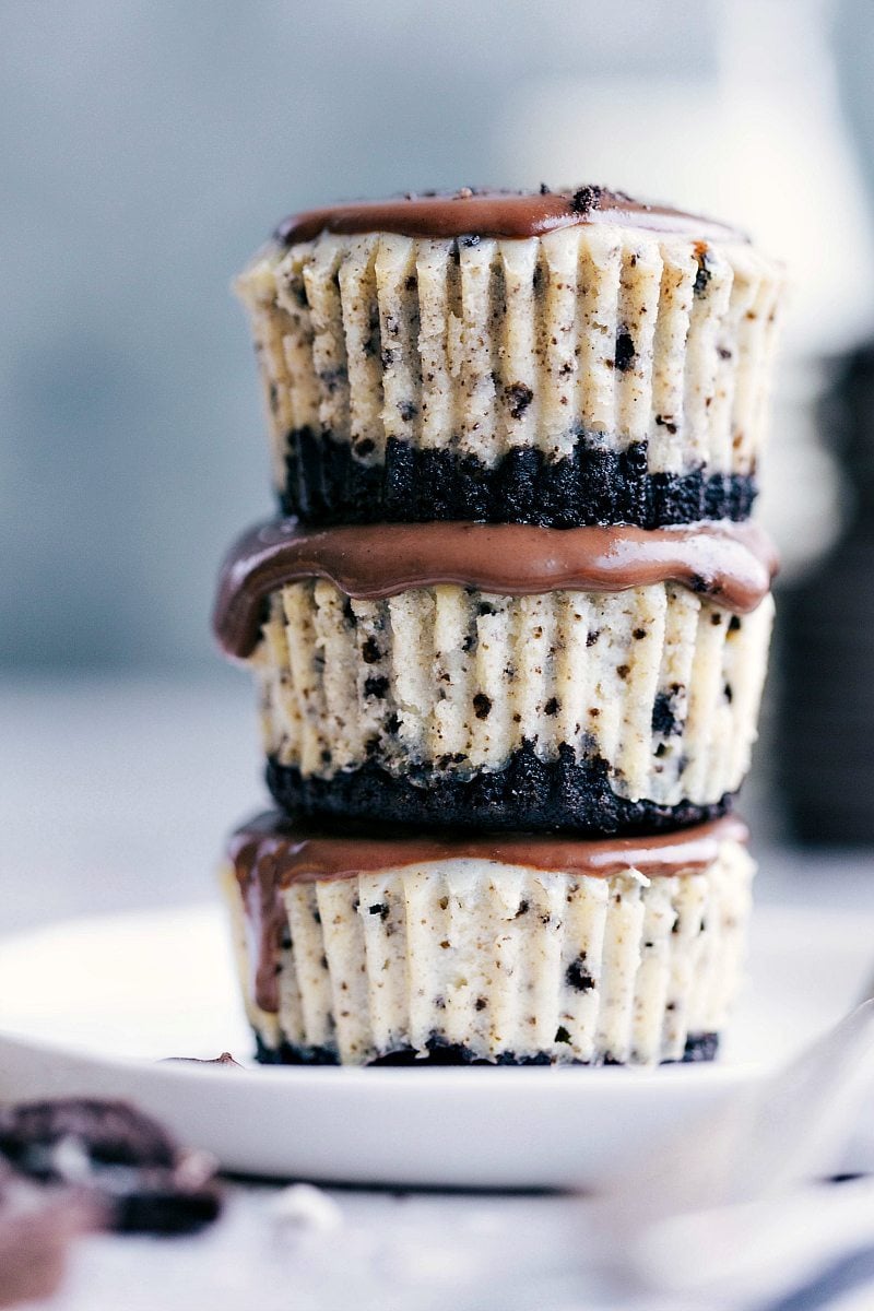 The ultimate BEST-EVER miniature oreo cheesecakes with an easy chocolate ganache. via chelseasmessyapron.com #mini #oreo #cheesecake #cheesecakes #dessert #easy #tips #kidfriendly #sweet #cookie #chocolate #ganache Three Mini Oreo Cheesecakes in a stack