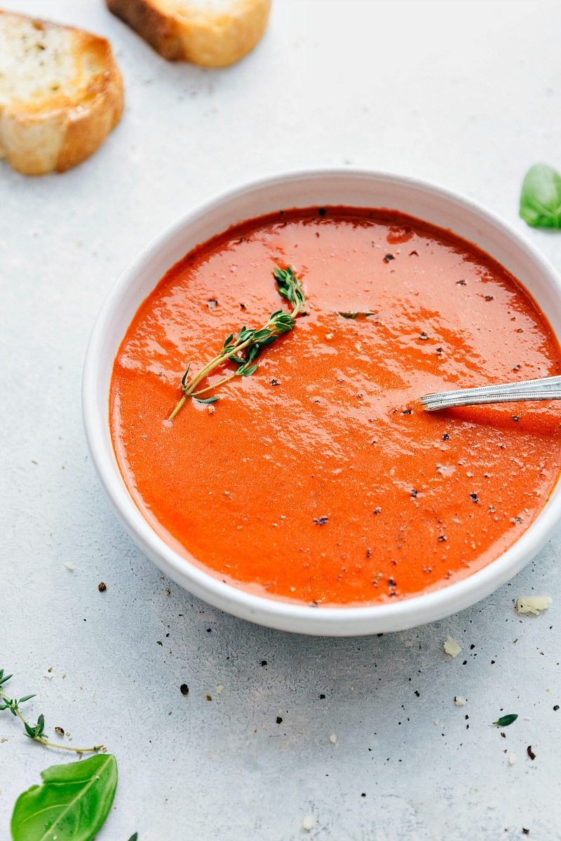 Tomato Basil Soup recipe in a bowl with fresh thyme.