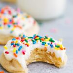 The finished soft sugar cookie recipe, featuring a delicious cookie with a thick layer of frosting on top, and a tempting bite taken out.