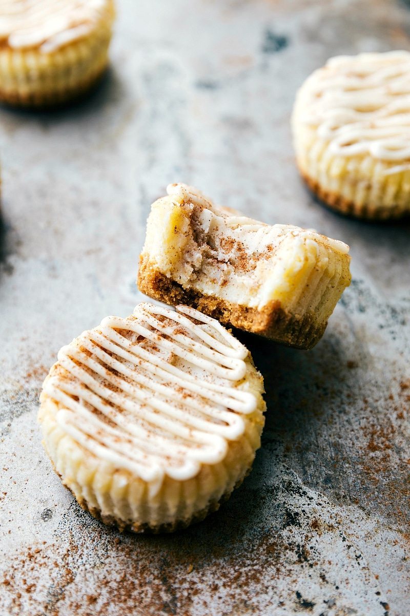 The BEST DESSERT! Miniature cinnamon roll cheesecakes with a delicious cinnamon swirl and cream cheese frosting topping! Via chelseasmessyapron.com