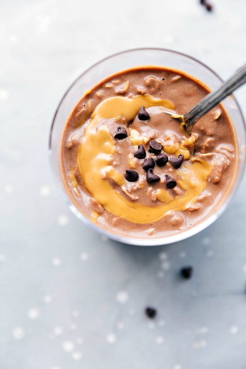 Peanut butter overnight oats, ready to be enjoyed on the go, with a peanut butter swirl mixed in and topped with chocolate chips.