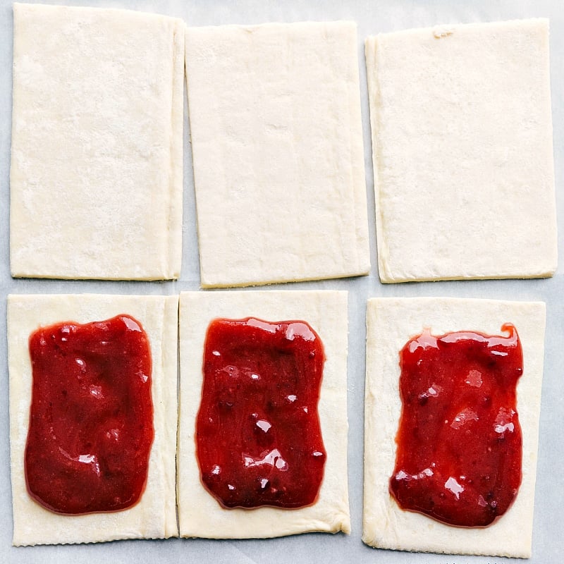 Puff pastry pieces with strawberry jam dolloped in the center.