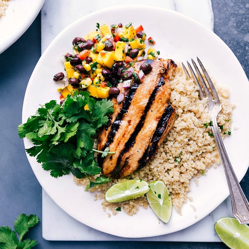 A delightful chicken quinoa bowl with mango salsa and rice, ready to be enjoyed.