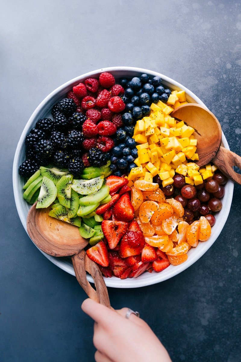 Overhead view of a bowl of assorted sliced fruits, ready to be mixed together