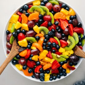 The easy fruit salad recipe in a bowl with serving spoons.