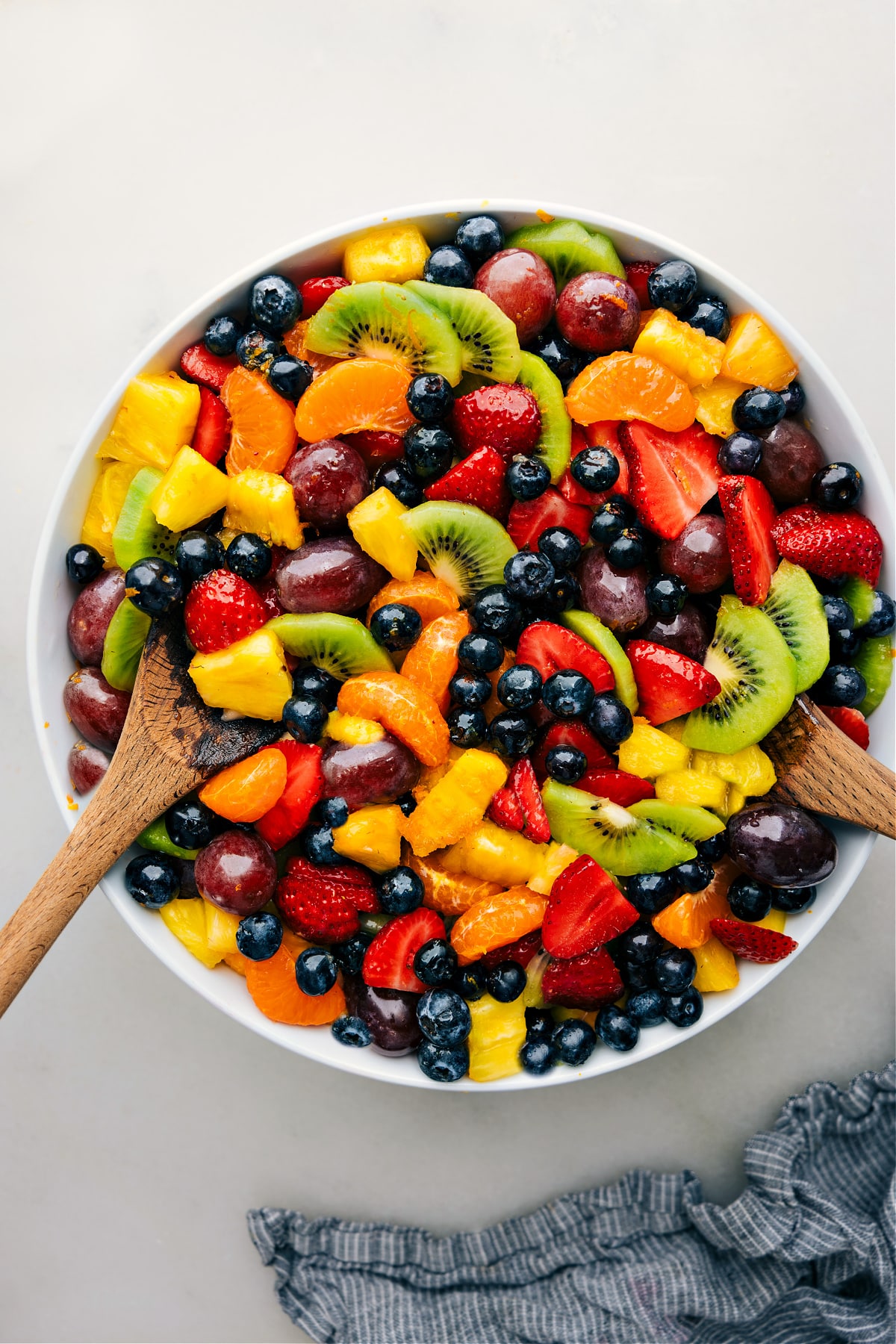 The easy fruit salad recipe in a bowl with serving spoons.