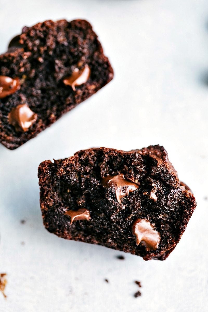 Halved peanut butter chocolate chip muffins with melted chocolate chips on the inside, showcasing their deliciousness.