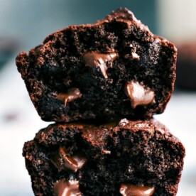 Chocolate peanut butter muffins, cut in half and stacked, revealing their soft interior with gooey chocolate chips.