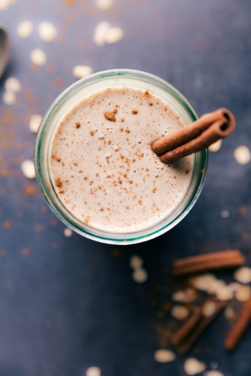 Oatmeal Smoothie in a cup with a stick of cinnamon in it.