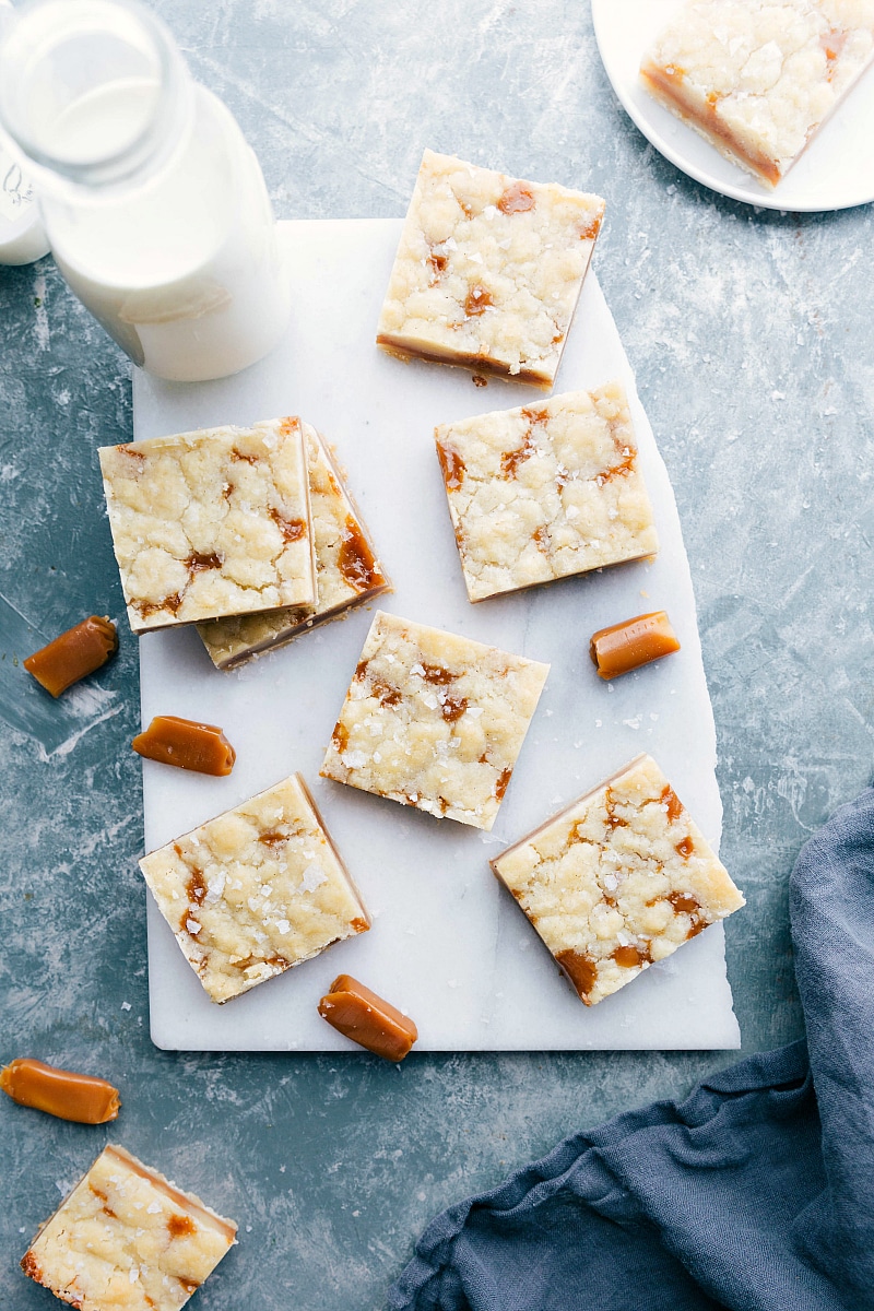 Overhead image of Caramel Cookie Bars, ready to eat with milk and caramels on the side.