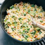 Creamy Orzo with a spoon in the pot.