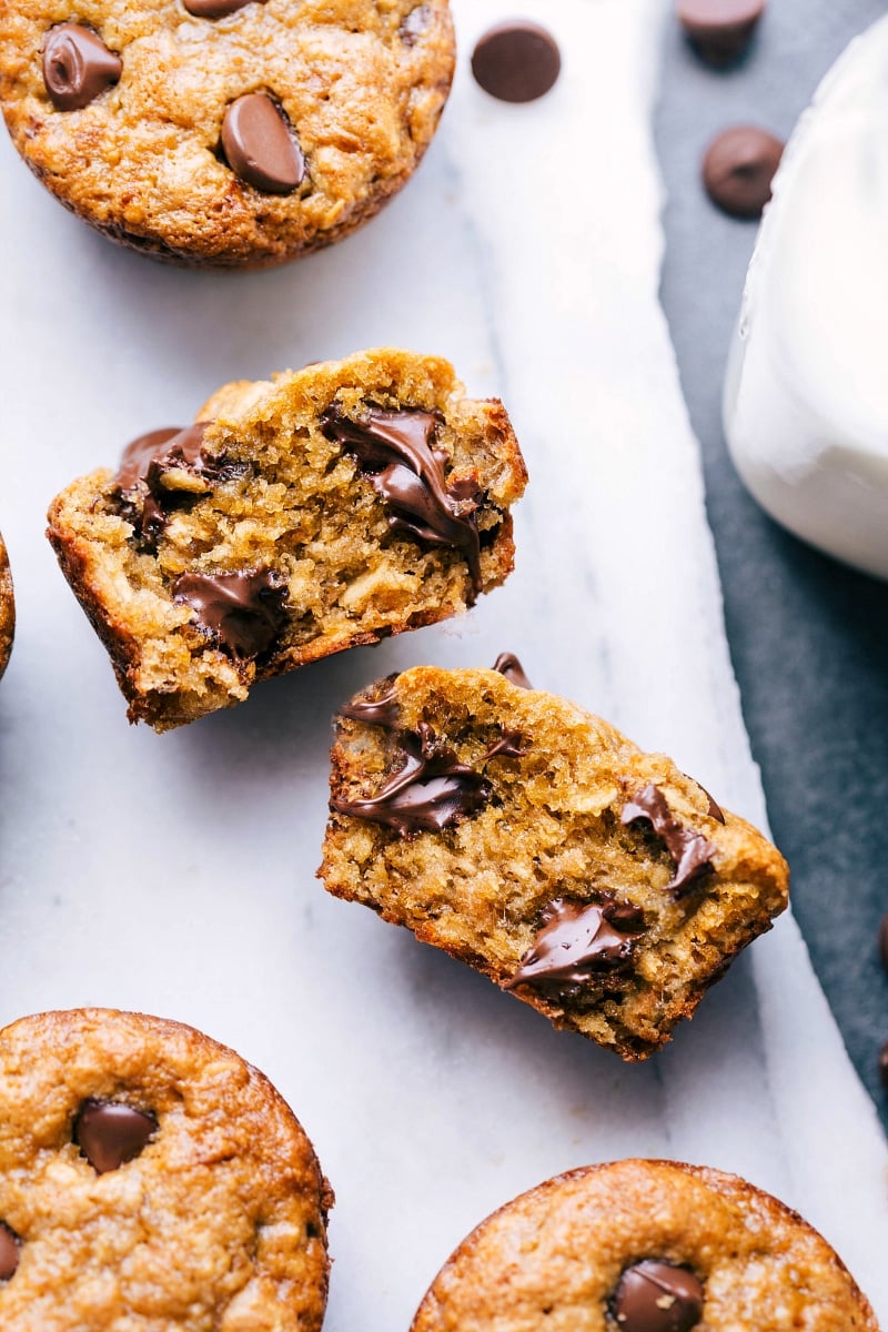 Peanut butter banana muffin broken open, revealing the delicious interior with melting chocolate chips.