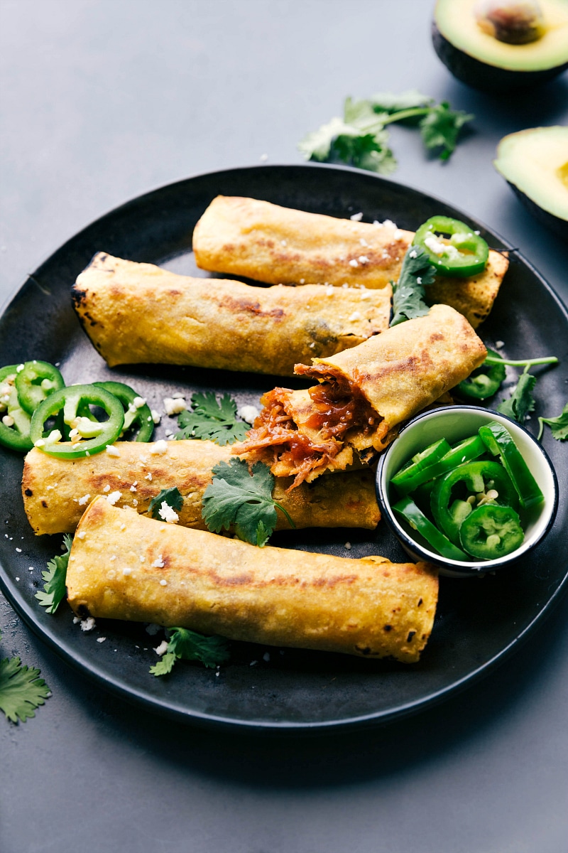 Image of Pork Taquitos on a plate with one broken apart to show the inside.