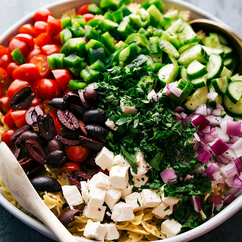 Process shots-- image of all the components of Greek Pasta Salad in a bowl.