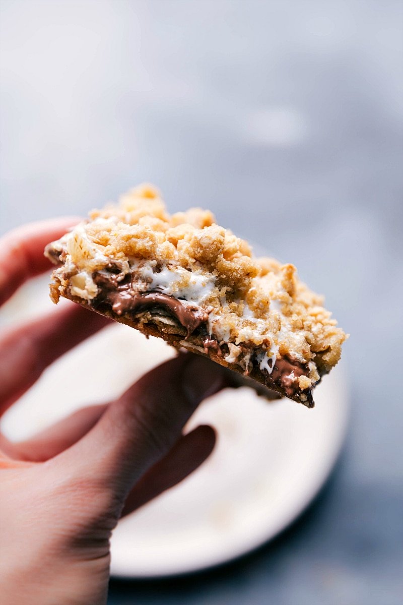 Image of a S'mores Cookie Bars being held, showing the gooey inside.