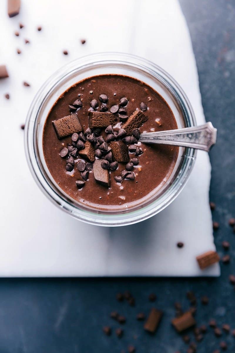 Brownie batter overnight oats, topped with chocolate chips and brownie bites for a sweet and delicious breakfast treat.