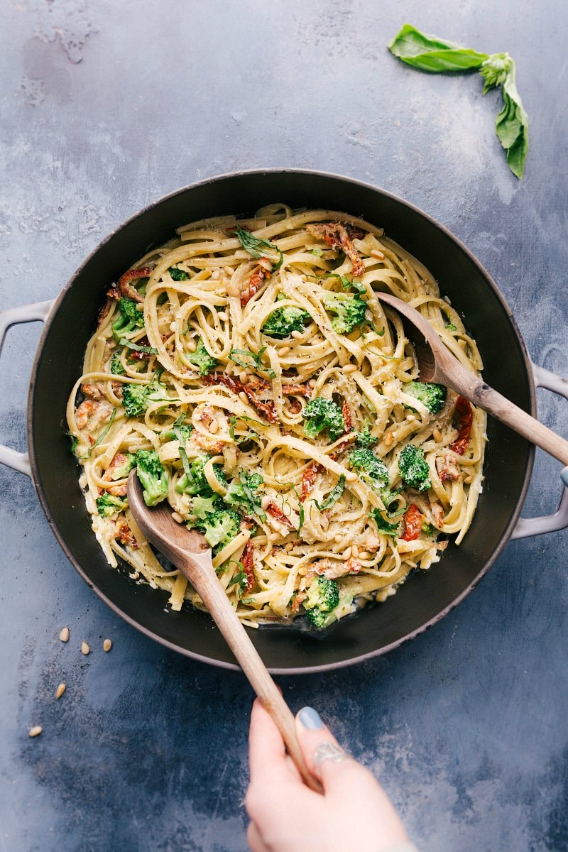 Overhead image of Creamy Pesto Pasta in the pot with serving spoons in it ready to be served and eaten.