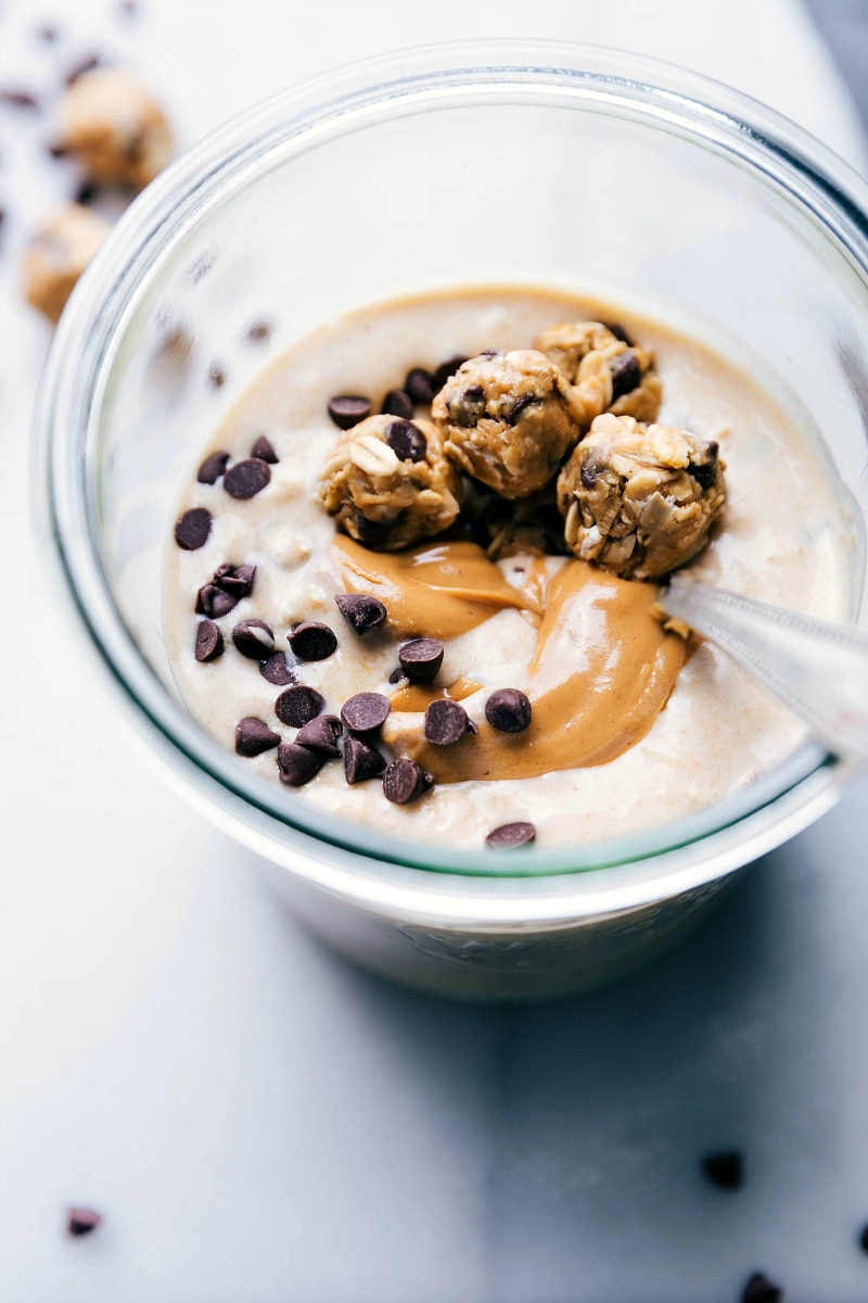 Finished peanut butter cookie overnight oats, ready to be eaten, with a spoon in the cup, a delicious breakfast.