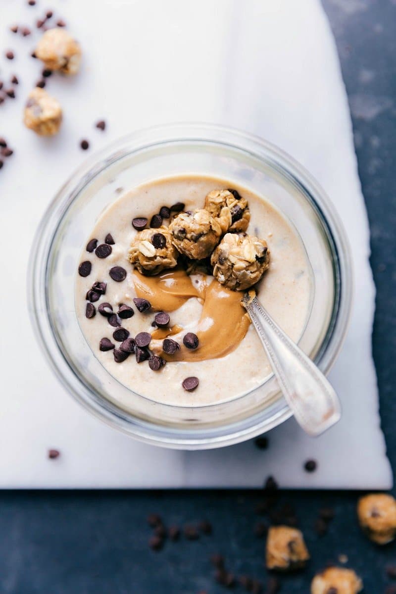 Peanut butter cookie overnight oats with a beautiful peanut butter swirl in it and mini cookie dough balls on top.