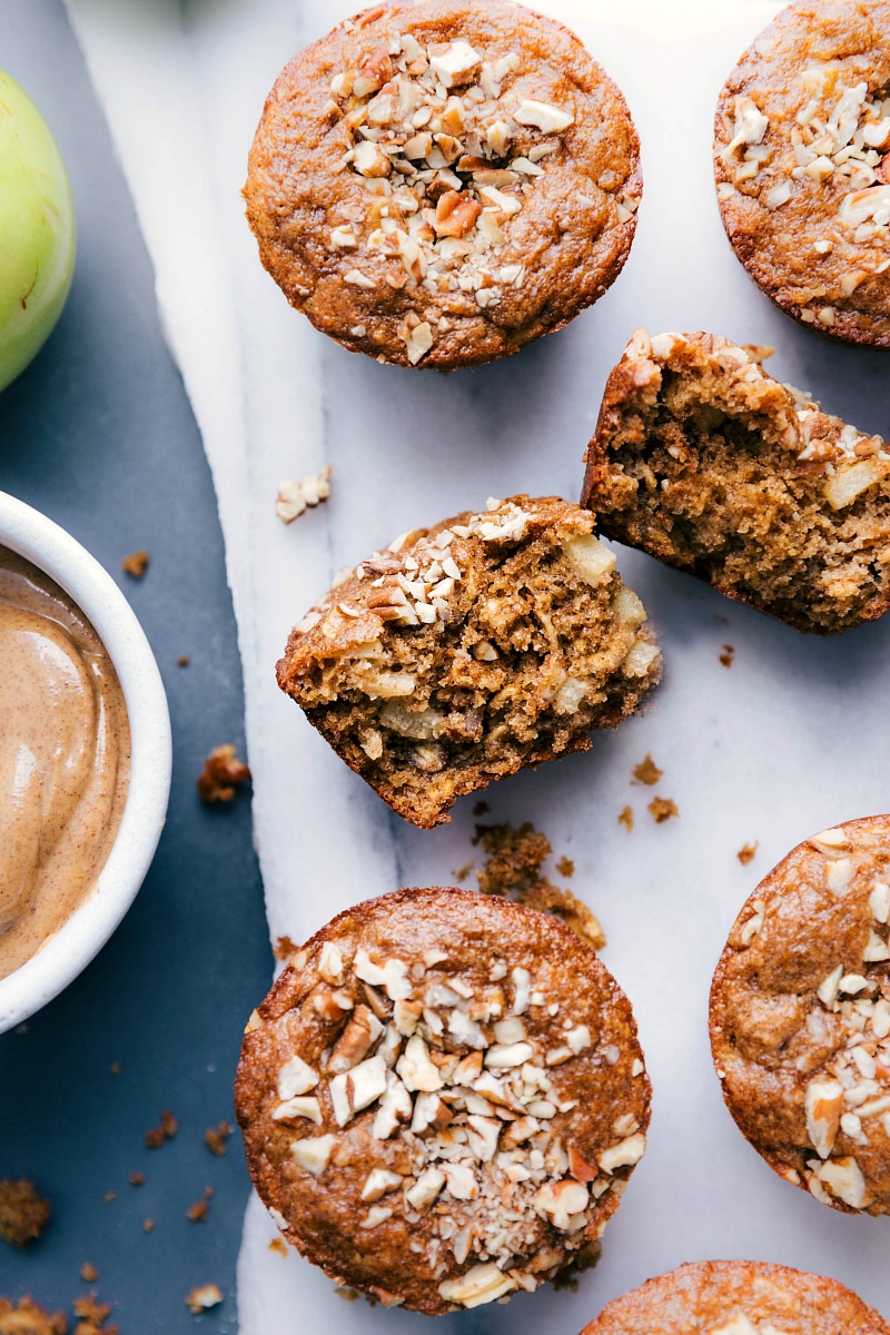 A sliced muffin revealing its delicious interior with chunks of apples.