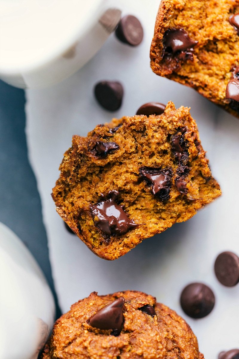 Healthy pumpkin muffin split open to reveal the soft and moist interior with melting chocolate chips, ready to be eaten.