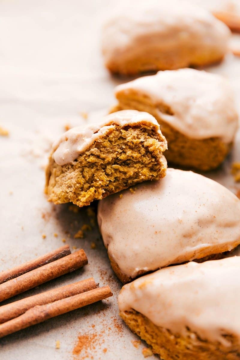 Upclose image of Pumpkin Scones with a bite taken out of one.