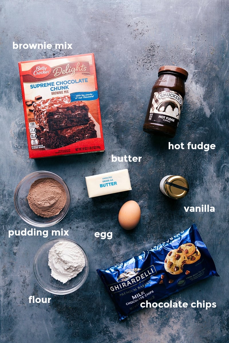 Assortment of ingredients for the fudge brownie cookie recipe, including cocoa powder, chocolate chips, and more.