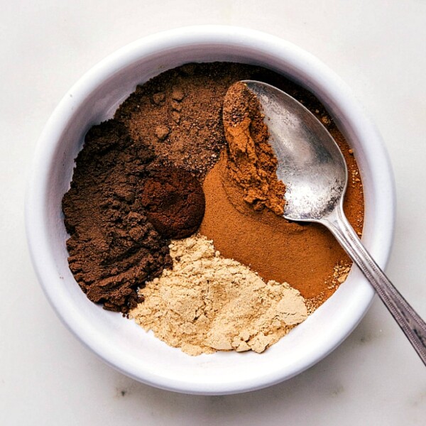 Assortment of ingredients for the pumpkin pie spice recipe, including cinnamon, nutmeg, and cloves.