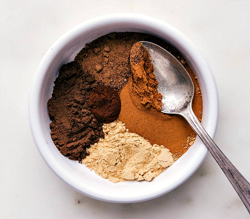 Assortment of ingredients for the pumpkin pie spice recipe, including cinnamon, nutmeg, and cloves.