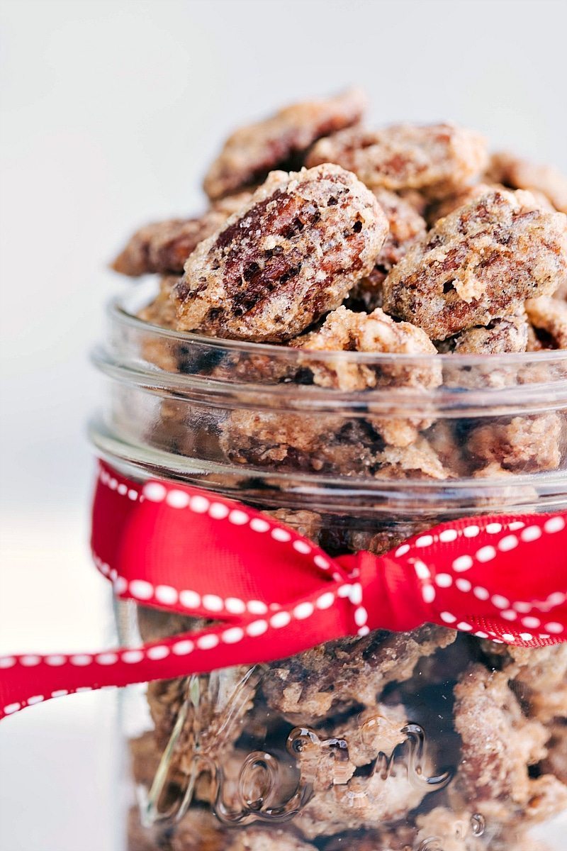 Close-up photo of a jar of Candied Pecans with red ribbon around the jar.