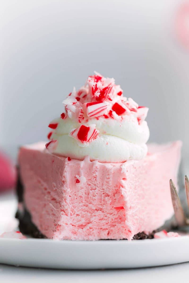 Slice of no-bake peppermint cheesecake with a bite missing, showcasing its creamy texture and peppermint layers.