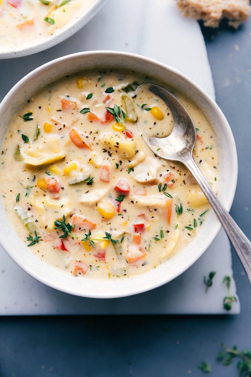 Overhead image of Creamy Chicken Tortellini Soup with a spoon in the bowl, ready to be eaten.