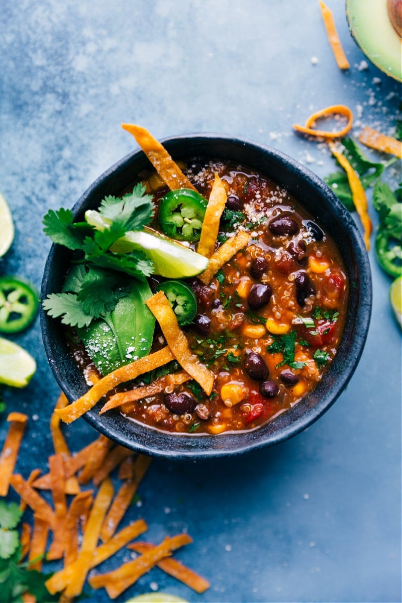 This Healthy Chicken Tortilla Soup has loads of hidden veggies, tender shredded chicken, and plenty of plant-based protein in the form of quinoa and beans -- it's a powerhouse of good-for-you ingredients! Cozy up with a big bowl with your favorite tortilla soup toppings and be prepared to be completely hooked on this soup! Recipe via ChelseasMessyApron #dinner #quick #easy #simple #clean #cleaneating #familyfriendly #kidfriendly #healthy #chicken #tortilla #soup Overhead image of Healthy Chicken Tortilla Soup