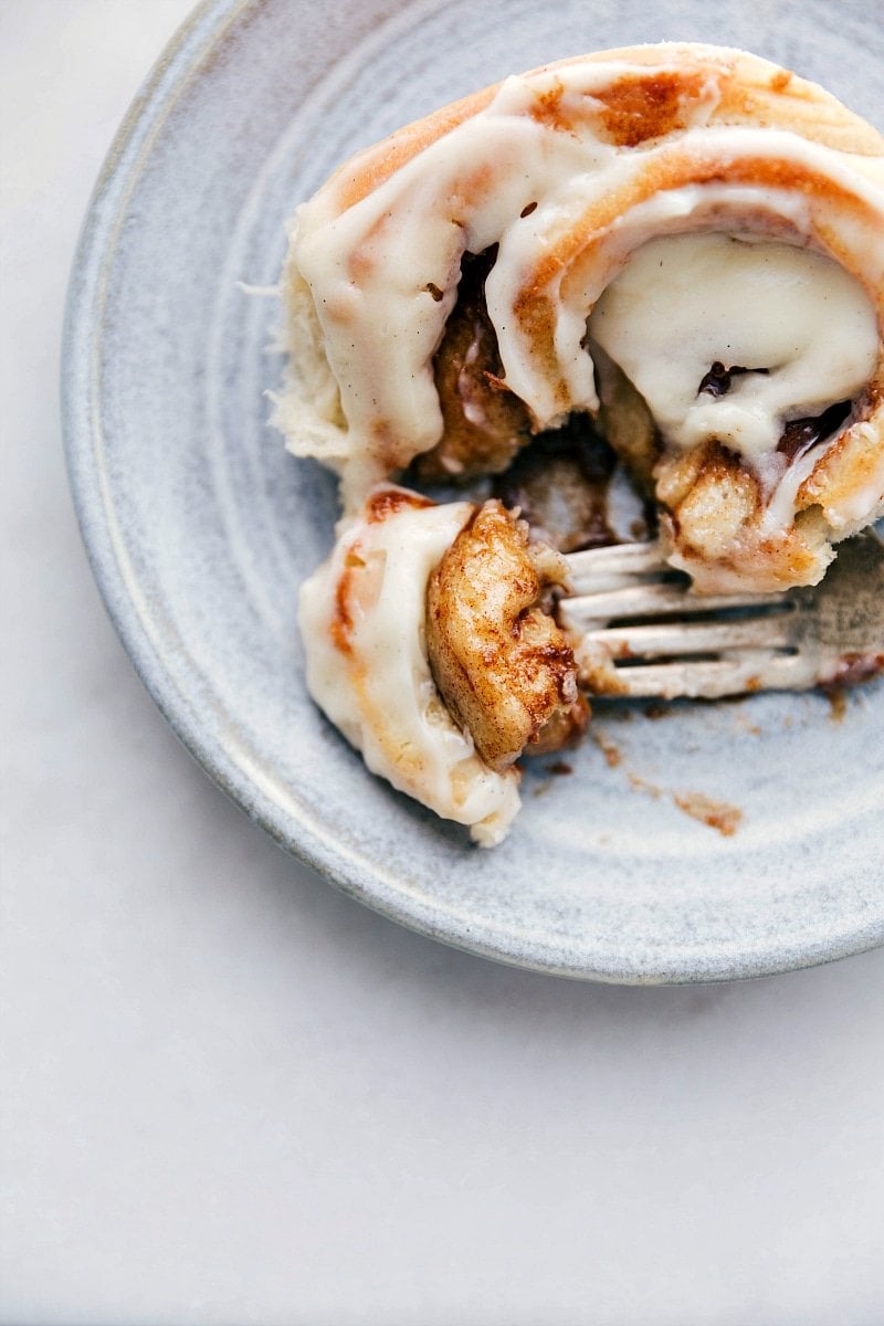 Up-close photo of a Homemade Cinnamon Roll with bite taken out of it.