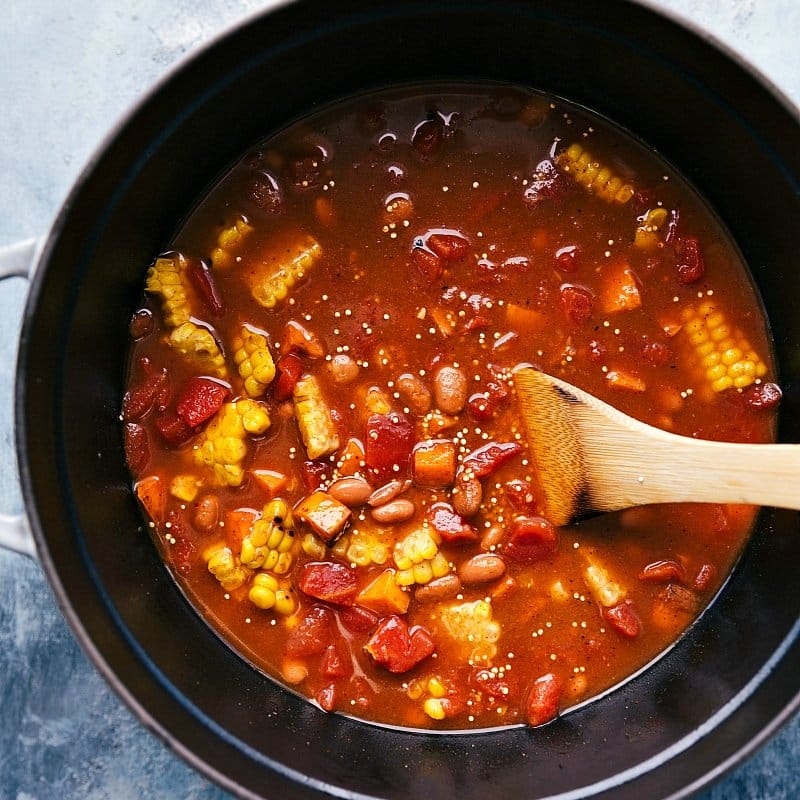 Vegetables and beans being added to the pot and mixed together, blending delicious and complementary flavors.