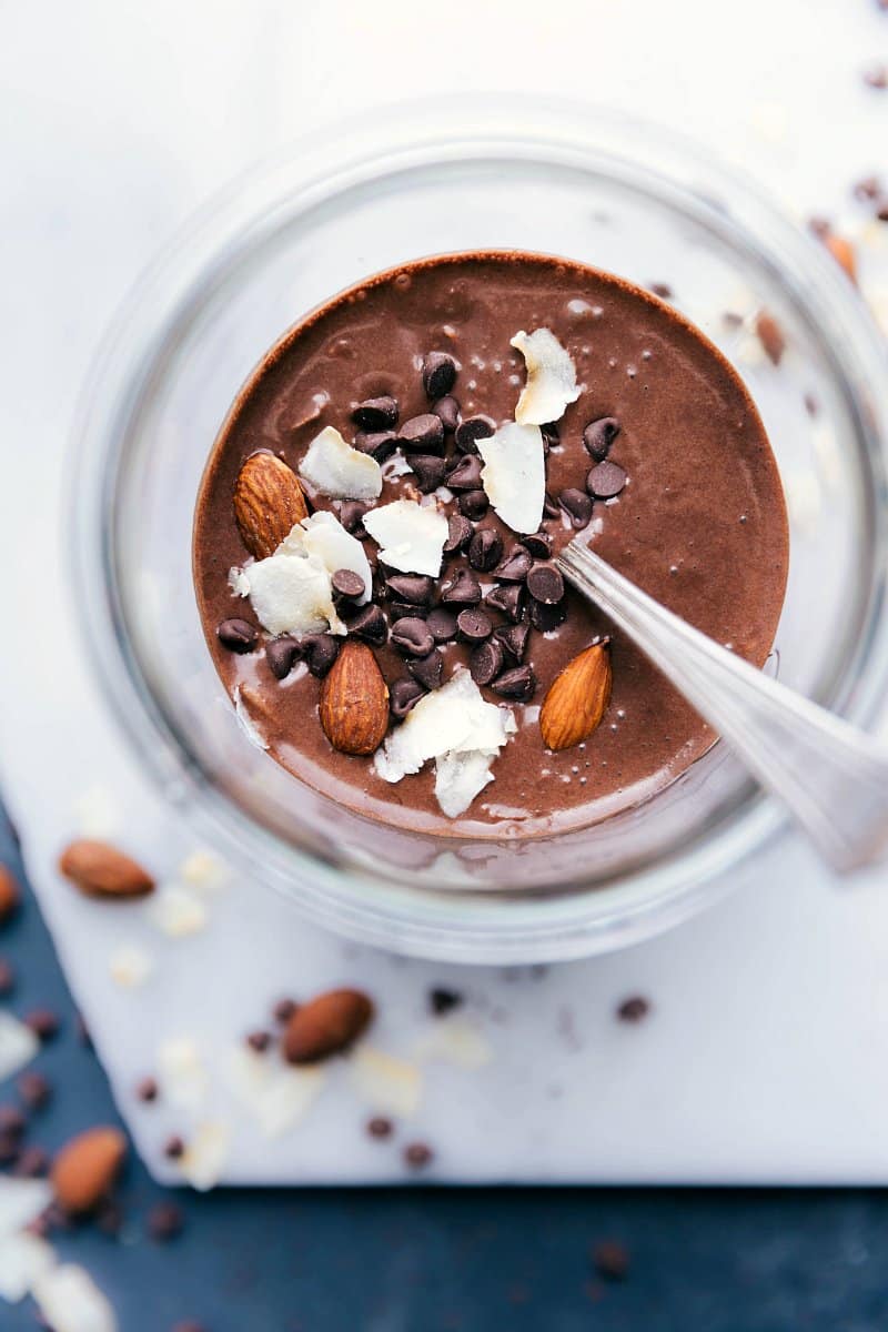 Overhead image of the chocolate version of this recipe with a spoon in it and mini chocolate chips, coconut, and almonds as toppings.