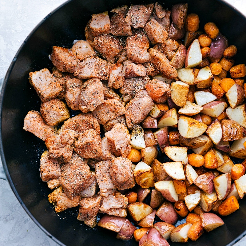 Chicken, potatoes and carrots in a skillet.