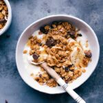 Bowl of creamy yogurt topped with Peanut Butter Granola, ready to be enjoyed.