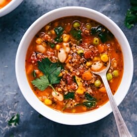 Healthy minestrone soup in a bowl with a spoon, featuring a variety of vegetables.