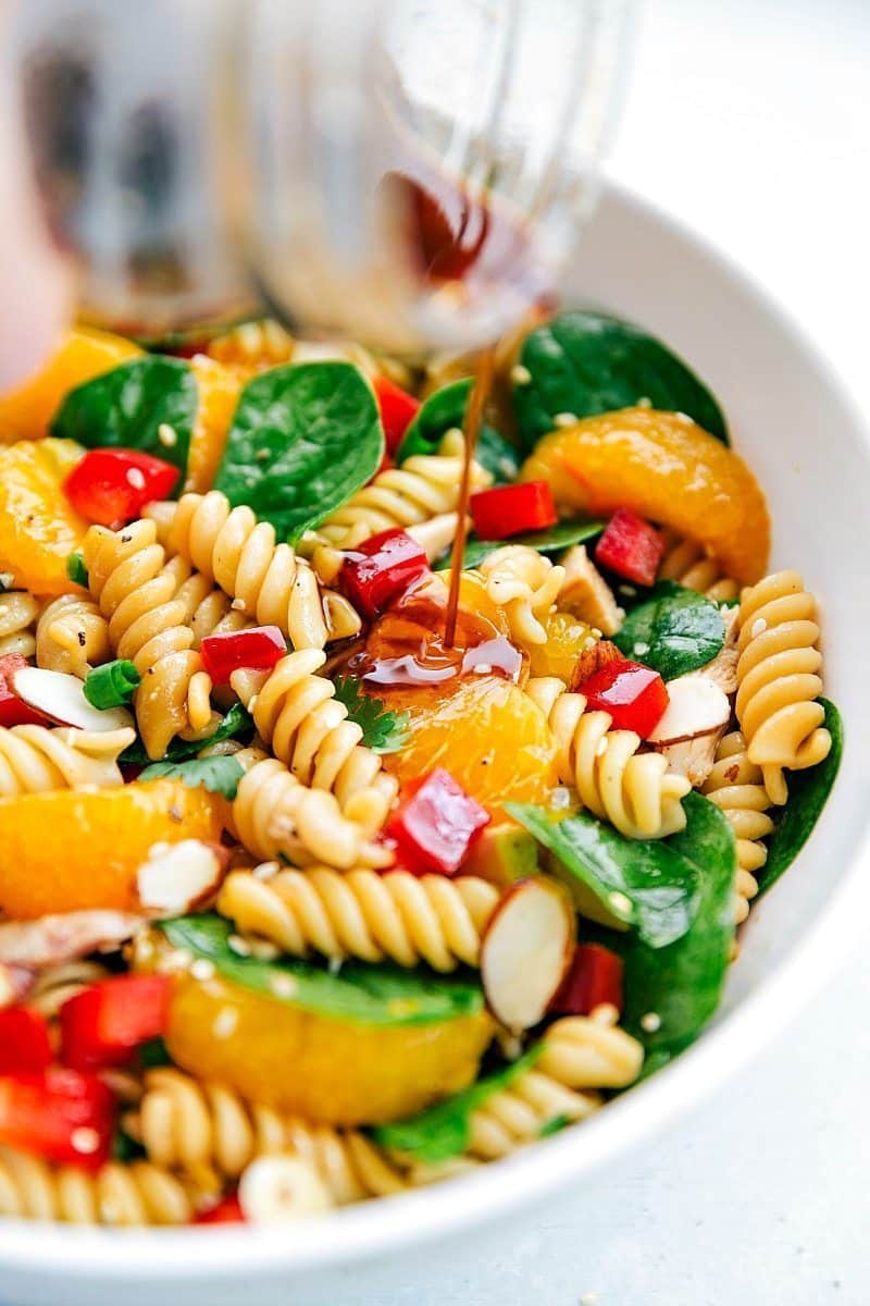 Image of the dressing being poured over the Asian Pasta Salad.